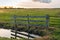 Wooden fence reflects in the mirror-smooth water surface of a po