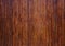 Wooden fence from rough pine oiled dark planks verticaly attached . Horizontal wood texture