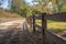 Wooden fence in the shade with dirt road