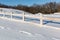 Wooden fence on winter farming field