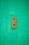 Wooden figure eight number on emerald wall