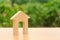 Wooden figure of a house with a large doorway on nature background. Home, Affordable housing, residential building