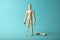 Wooden figure of man with artificial prosthetic leg. Amputee and disability concept