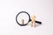 A wooden figure of a woman stands near the magnifying glass, behind which stands a child. The concept of finding a child