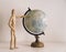 Wooden figures choosing travel destination on a world map. Travel lifestyle, happiness moments