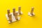 Wooden figures on puzzles on yellow background as a symbol of team building. Organization group people in business. Cooperation