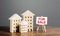 Wooden figures of residential buildings and an easel sign labeled for sale. Buying and selling real estate, hot offers and