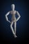 Wooden figurine crossing legs in elegant dancing move on dark ba