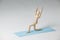 Wooden figurine exercising on exercise mat