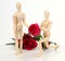 Wooden figurine man holding and giving rose to lover with rose b