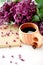 Wooden finnish cup with coffee on the table. Nearby lies a closed notebook for notes and a bouquet of lilacs. Good morning and goo