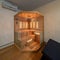Wooden Finnish sauna in room of private house. Lounge zone. Coffee table with candle.