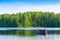 Wooden fishing boat on a calm lake by a pine forest