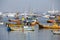 Wooden fishing boats and expensive yachts on the sea water near the city of Mumbai, India