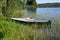 Wooden fishing boats at the shore of a forest lake, standing in the grass