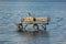 Wooden fishing platform in water, with tire fenders and chair