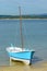 Wooden fishing sailboat anchored near the shore