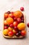 Wooden flat plate with fresh cherries, plums and apricots with water drops, close up