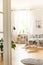 A wooden floor bedroom interior with a bed and a breakfast tray. Window with see-through curtains in a background. Real photo.