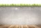 Wooden floor and concrete wall on green leaves background