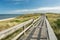 Wooden foot bridge through the dunes with the ocean in the background in Northern Germany