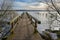 Wooden footbridge jetty on the frozen lake of Ratzeburg, last winter days in early spring, landscape in north Germany, copy space