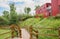 Wooden footbridge before red container building in cloudy summer