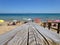 Wooden footbridge on the sandy beach in summer