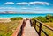 Wooden footbridge to the oasis-like beach - Spiaggia della Pelosa. Scenic spring view of Sardinia island, Italy, Europe. Bright mo