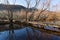 Wooden footpath river crossing landscape with barren trees and mountains