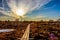 Wooden footpath in swamp with beautiful evening sun light at sunset and autumn colored flora of winter bog, Northern Europe nature