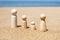 Wooden four figures of people on the sand of beach with sea view. Concept of happy family with two kids on holiday.