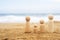 Wooden four figures of people on the sand of beach with sea view. Concept of happy family with two kids on holiday.