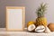 Wooden frame with melon, coconut, pineapple, seashells on gray pastel background. Side view, copy space