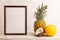 Wooden frame with pineapple, melon, coconut on gray concrete background. Side view, copy space