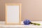 Wooden frame with spring snowdrop flowers bluebell on beige pastel background. top view, copy space, mockup, template