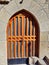 Wooden front door with arch and glass at an old stone building.