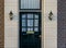 Wooden front door of a luxurious house with two unlit lanterns, Modern Dutch architecture background