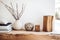 Wooden furniture and decor of home interior close-up, vases and books on wood shelf on white wall background. Detail of living