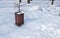 Wooden garbage or junk can for trash in the park covered with snow in the winter season to protect from environment pollution