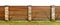 Wooden garden fence with stone paved pillars guarding private pr