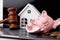 Wooden gavel, broken piggy bank and white house. Real estate auction concept