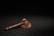 a wooden gavel with a gold clip for an auction on a stand on a wooden table. 3d render