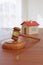 Wooden gavel and and house toy. Concept of real estate law. 3d illustration