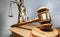 Wooden gavel of a judge with the statue of justice in the background