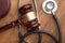 Wooden gavel and stethoscope on wooden background