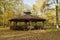 Wooden gazebo in autumn parks - relax and unwind