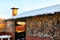 Wooden gazebo with chimney in the yard on a Sunny winter day