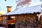 Wooden gazebo with chimney in the yard on a Sunny winter day