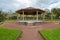 Wooden gazebo with concrete floor under slate roof in park